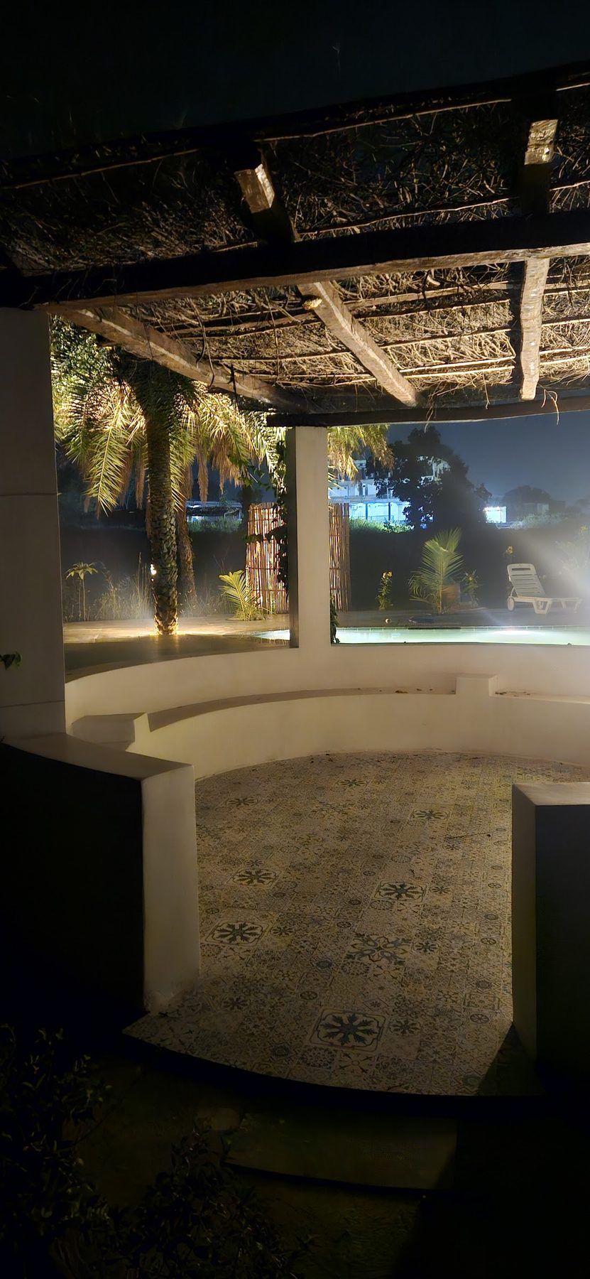 Pergola and stone seating by the pool at night